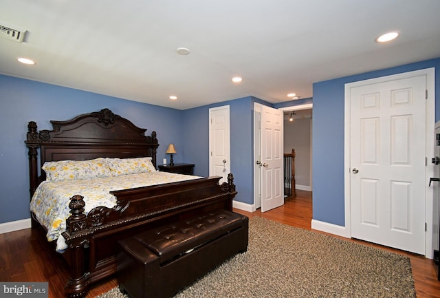 bedroom featuring wood finished floors, visible vents, recessed lighting, and baseboards