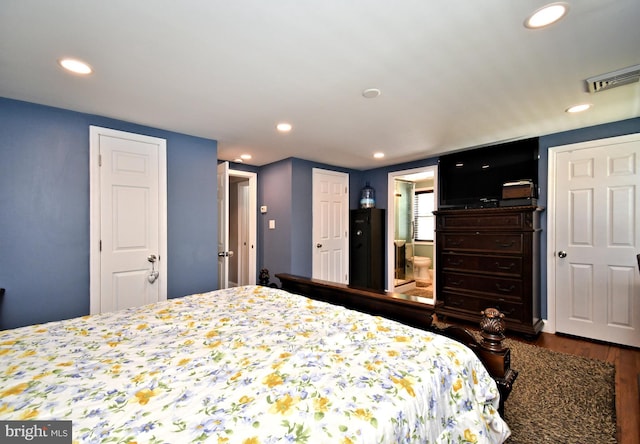 bedroom featuring visible vents, recessed lighting, ensuite bath, and dark wood finished floors