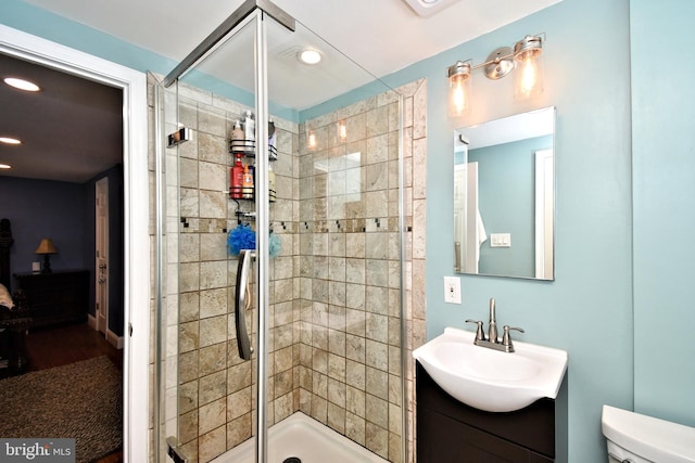 full bath featuring recessed lighting, a shower stall, toilet, and vanity
