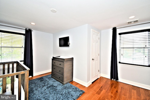 bedroom featuring baseboards, visible vents, wood finished floors, and recessed lighting