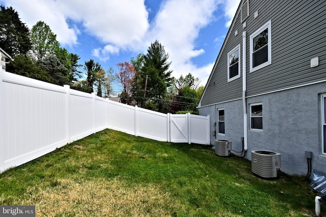 view of yard featuring central AC unit and a fenced backyard