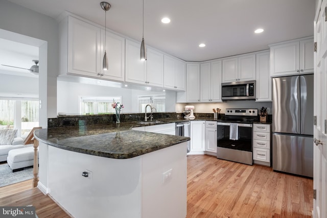 403 Thomas St, Alexandria, VA 22302 - kitchen with a sink, light wood-style floors, stainless steel appliances, white cabinetry, and a peninsula