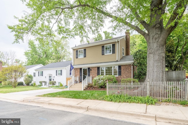 403 Thomas St, Alexandria, VA 22302 - view of front of house featuring brick siding, a chimney, fence private yard, and a front yard