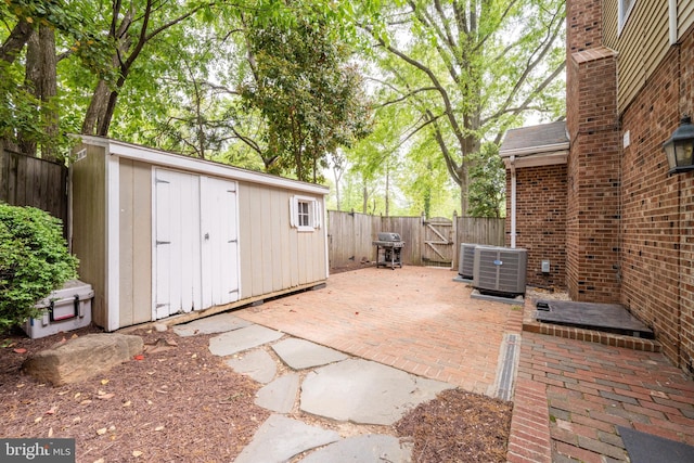 403 Thomas St, Alexandria, VA 22302 - view of patio featuring an outdoor structure, a fenced backyard, a storage unit, a gate, and central air condition unit