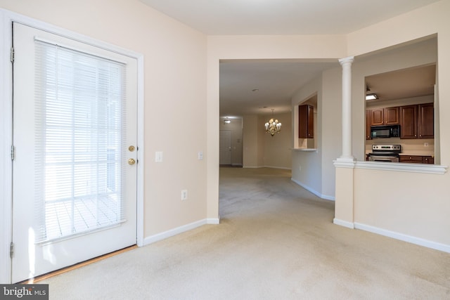interior space with ornate columns, baseboards, light colored carpet, and an inviting chandelier