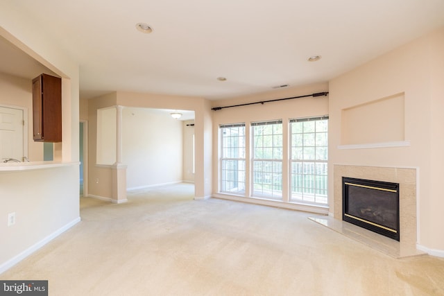 unfurnished living room with baseboards, recessed lighting, a fireplace, and light carpet