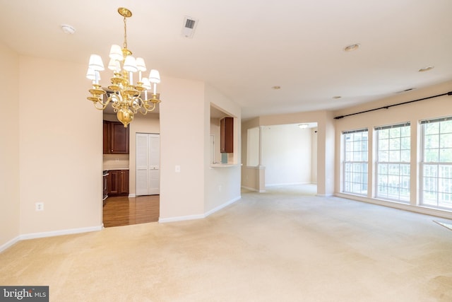 unfurnished room with an inviting chandelier, baseboards, and light colored carpet