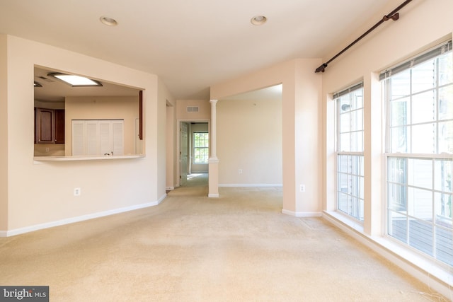 spare room featuring light colored carpet, recessed lighting, baseboards, decorative columns, and visible vents