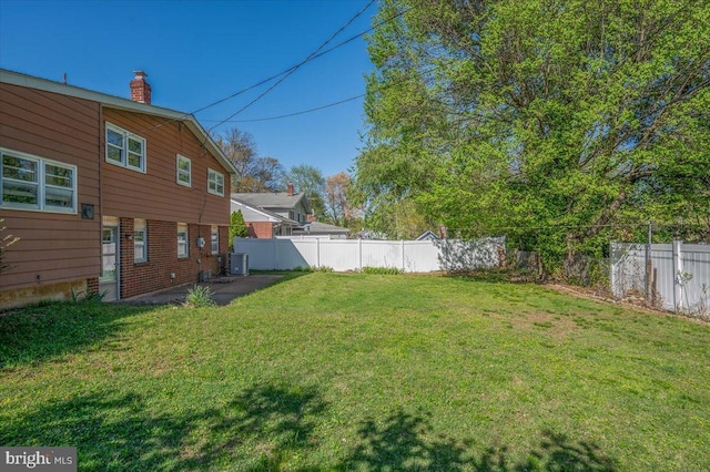 view of yard with fence and central AC