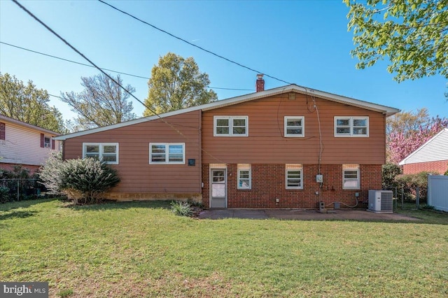 rear view of house featuring fence, a yard, and central air condition unit