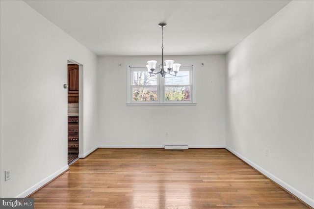 unfurnished dining area featuring wood finished floors, visible vents, and a notable chandelier
