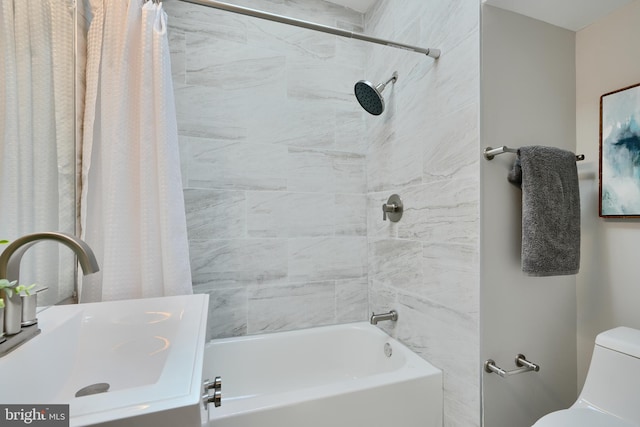 bathroom featuring a sink, shower / tub combo, and toilet