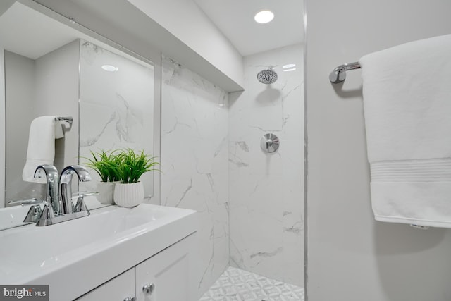 full bath with a marble finish shower and vanity