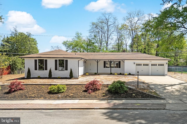 ranch-style house featuring a garage, fence, and driveway
