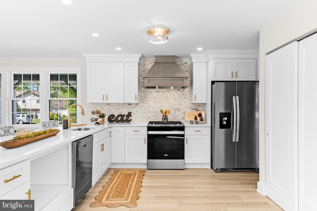 kitchen featuring custom range hood, a sink, light countertops, stainless steel appliances, and white cabinetry
