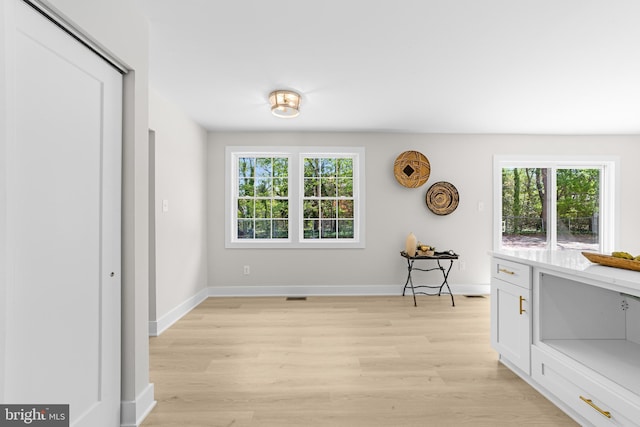 dining area with baseboards, light wood-style flooring, and visible vents