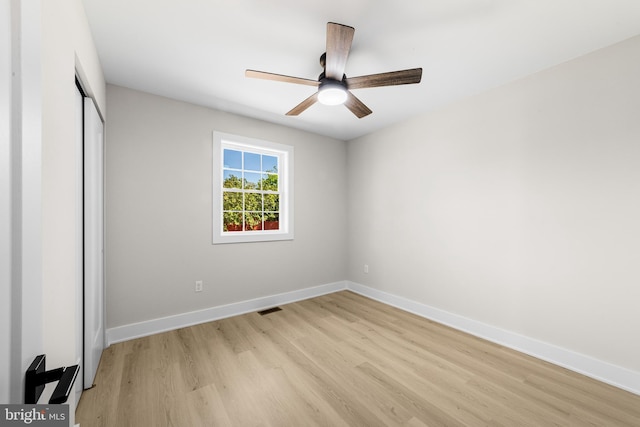 unfurnished bedroom featuring a closet, visible vents, baseboards, a ceiling fan, and light wood finished floors