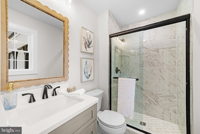 full bathroom with vanity, a stall shower, and toilet