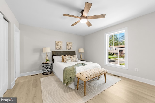 bedroom featuring baseboards, wood finished floors, and visible vents