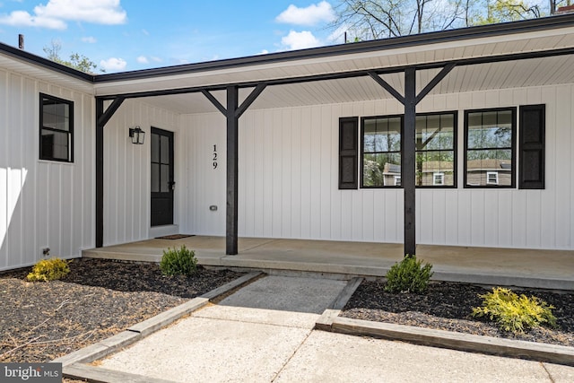 view of exterior entry featuring covered porch