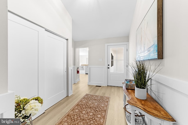 interior space featuring light wood-style floors and a wainscoted wall