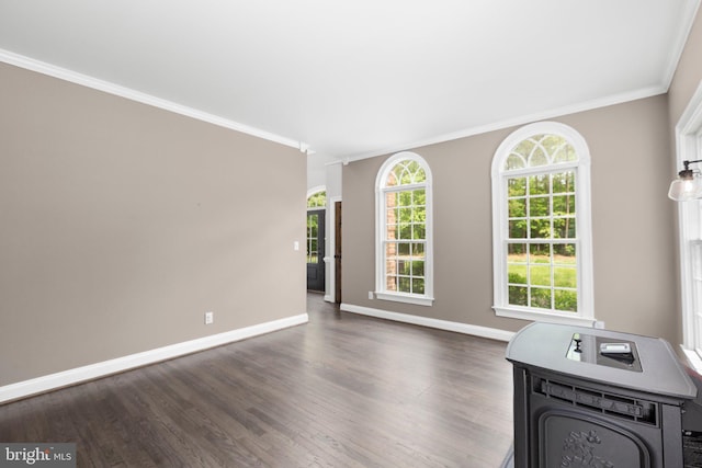 unfurnished living room with ornamental molding, dark wood-type flooring, and baseboards