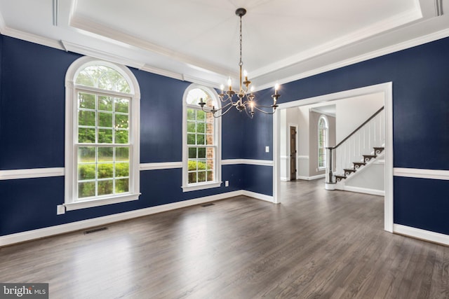 unfurnished dining area with a tray ceiling, a chandelier, wood finished floors, stairs, and ornamental molding