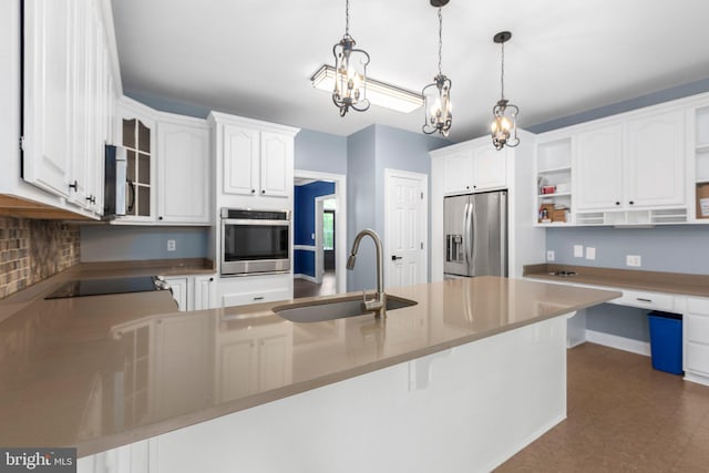 kitchen with appliances with stainless steel finishes, a sink, open shelves, a chandelier, and a peninsula