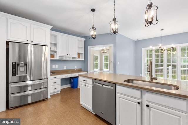 kitchen featuring appliances with stainless steel finishes, a sink, a chandelier, open shelves, and white cabinetry