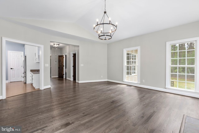unfurnished dining area featuring a chandelier, dark wood-style floors, baseboards, and lofted ceiling