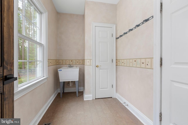 clothes washing area featuring baseboards