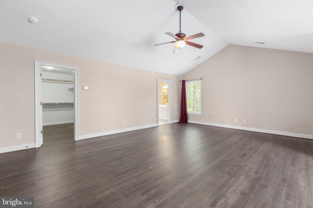 unfurnished living room with a ceiling fan, vaulted ceiling, dark wood finished floors, and baseboards