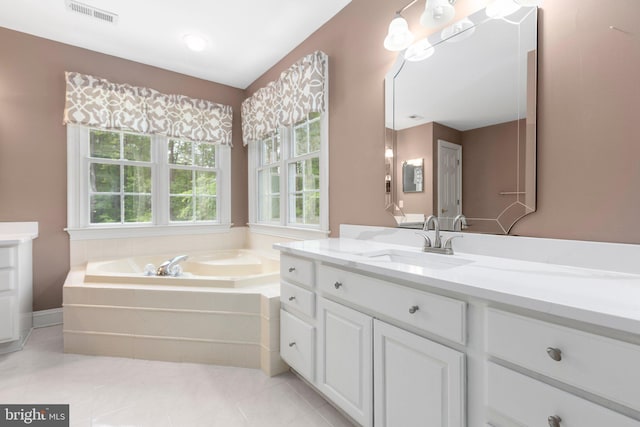bathroom featuring a garden tub, vanity, and tile patterned flooring