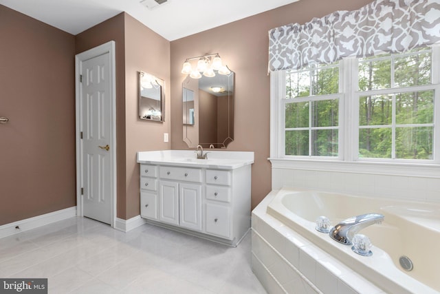 full bath featuring a garden tub, vanity, baseboards, and tile patterned flooring
