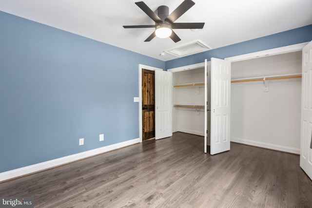 unfurnished bedroom with attic access, wood finished floors, baseboards, and ceiling fan