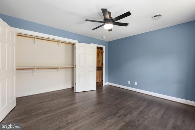 unfurnished bedroom with dark wood-type flooring, baseboards, and a closet