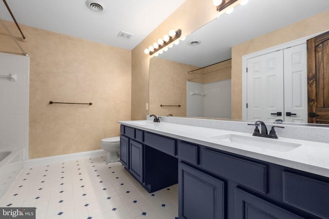 bathroom featuring toilet, double vanity, shower / washtub combination, and baseboards