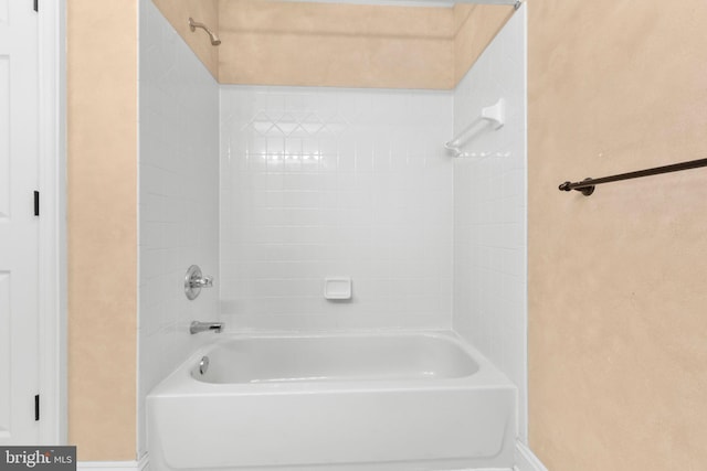 bathroom featuring baseboards and tub / shower combination