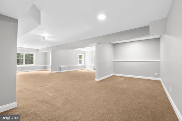 below grade area featuring carpet floors, baseboards, healthy amount of natural light, and recessed lighting