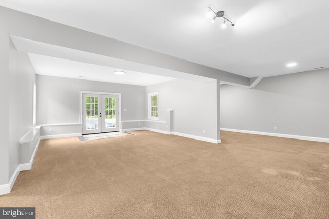 unfurnished living room featuring light colored carpet, baseboards, french doors, and recessed lighting