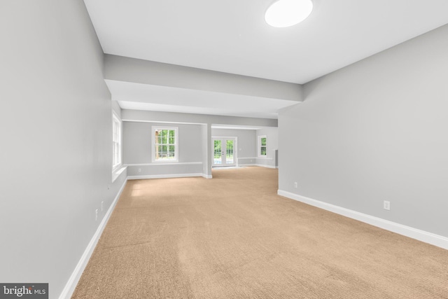 empty room featuring baseboards and light colored carpet
