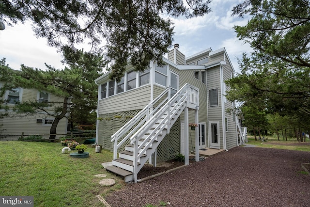 1105 N Bay Shore Dr, Milton, DE 19968 - back of house with stairs, a yard, a sunroom, and a chimney