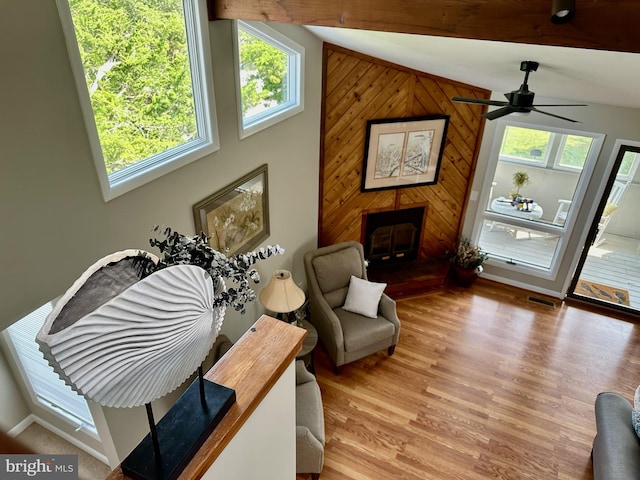 1105 N Bay Shore Dr, Milton, DE 19968 - living area featuring wood finished floors, a wood stove, wood walls, ceiling fan, and beamed ceiling