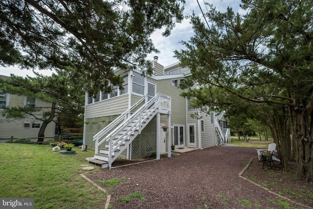 1105 N Bay Shore Dr, Milton, DE 19968 - back of house with stairway, a sunroom, a yard, french doors, and a chimney