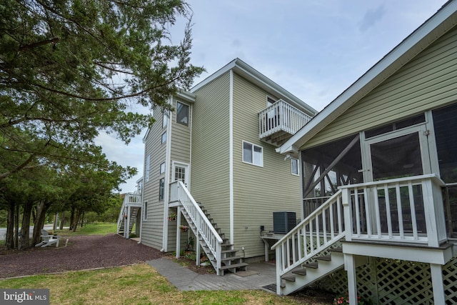 1105 N Bay Shore Dr, Milton, DE 19968 - rear view of house featuring stairway, a sunroom, a balcony, and cooling unit