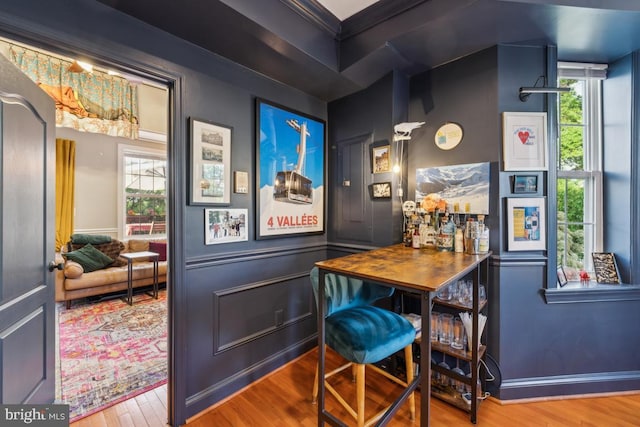 bar featuring crown molding, wood finished floors, and a wealth of natural light