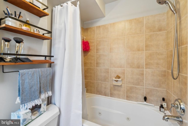 bathroom featuring toilet and a combined bath / shower with jetted tub