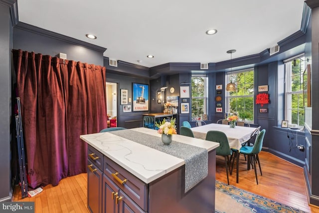 kitchen featuring crown molding, recessed lighting, light wood-style floors, and a kitchen island