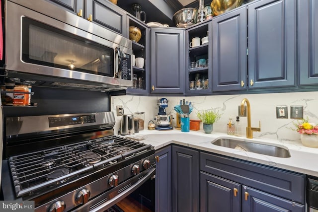 kitchen with a sink, open shelves, stainless steel appliances, and blue cabinetry