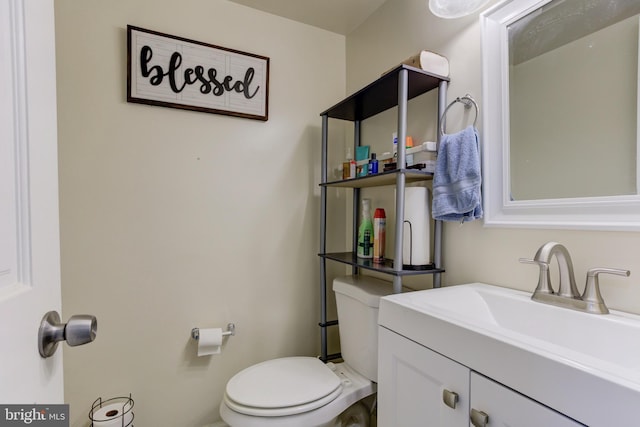 half bathroom with vanity and toilet